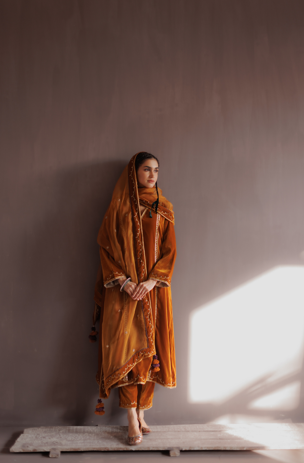 Mustard silk velvet hand embroidered kurta set.
